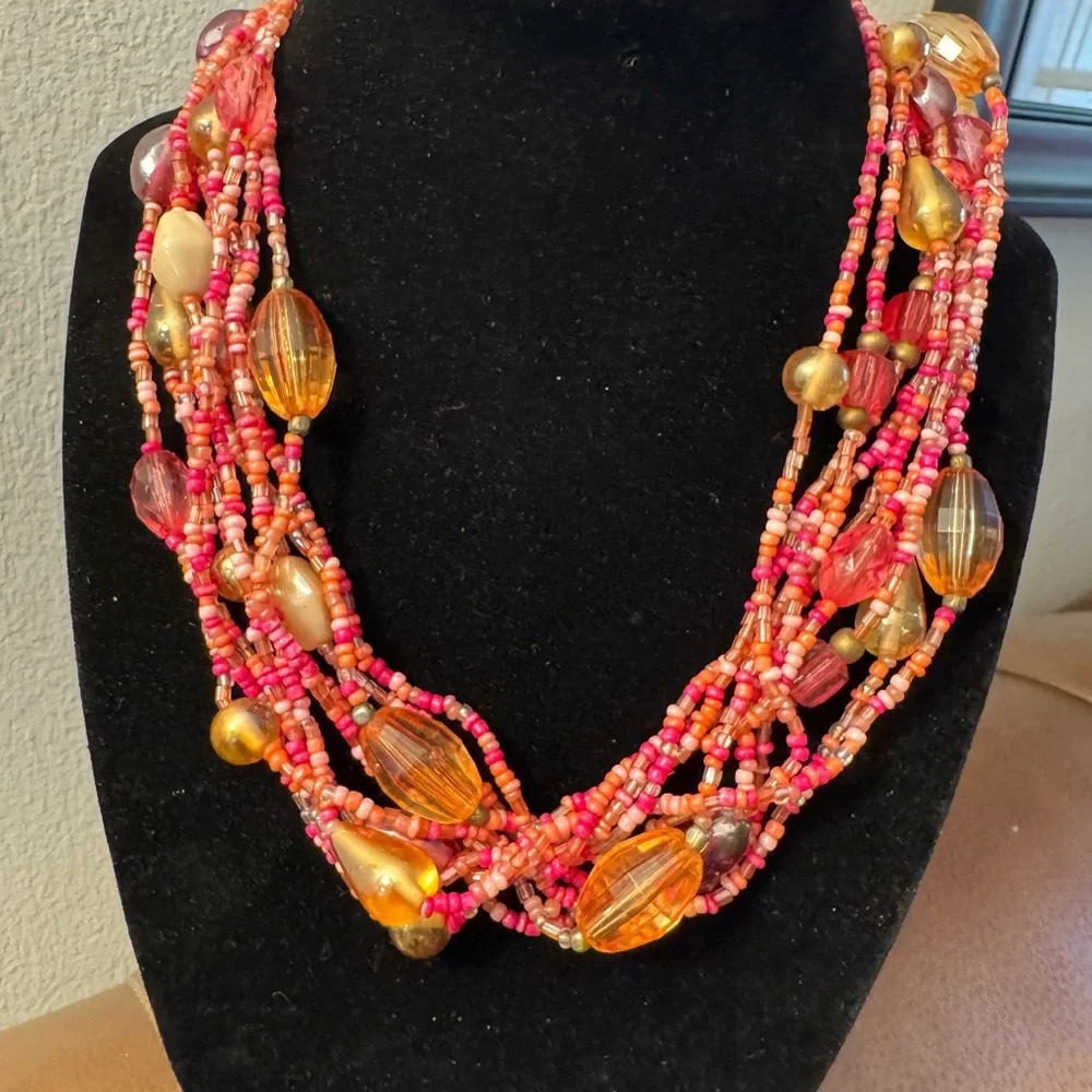 Multi strand torsade style necklace w/coral,pink and salmon colored seed beads